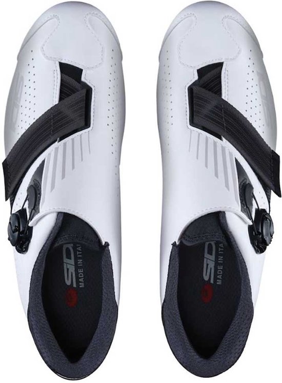 Bovenkantaanzicht van witte fietsschoenen met zwarte sluitingen en grijze details.