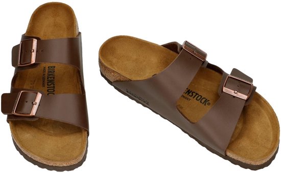 Paar bruine Birkenstock Arizona slippers met koperkleurige gespen.