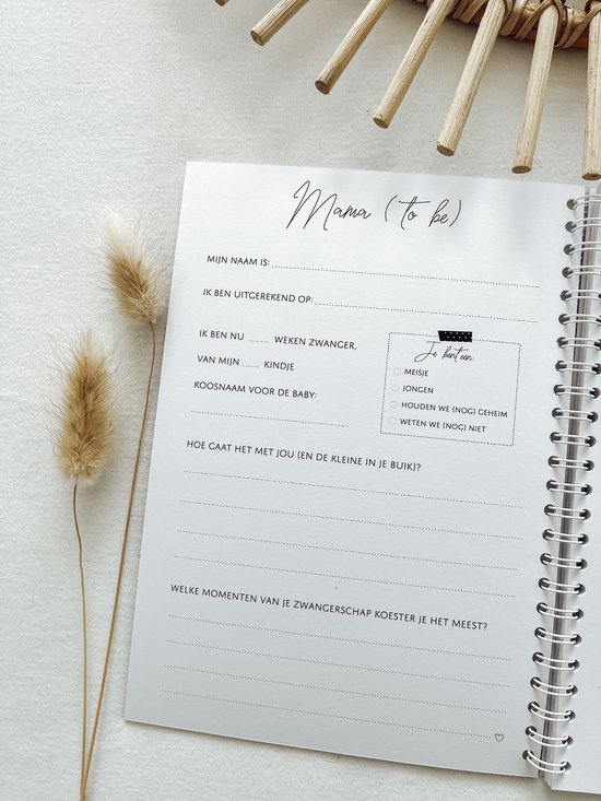 Wit invulboek met de titel 'Mama (to be)' en gedroogde bloemen.