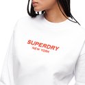 Gros plan de l'inscription rouge 'SUPERDRY NEW YORK' sur un sweat blanc.