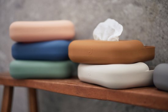 Stapel van verschillende kleuren siliconen doosjes voor billendoekjes, waarvan één open met witte doekjes eruit.