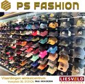 Nombreuses casquettes dans un magasin, y compris des casquettes Yankees orange, bleues, roses et grises.