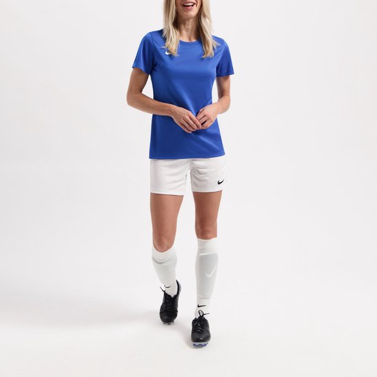 Femme portant un haut bleu, un short blanc et des chaussettes de sport blanches