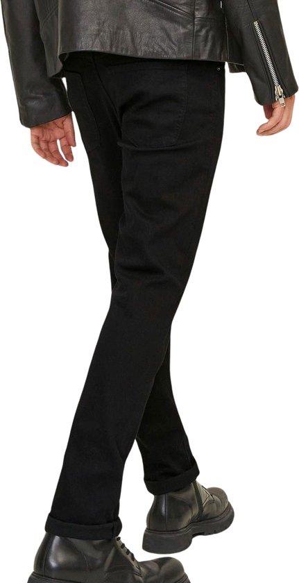 Man in zwarte jeans, bewegend met een zwarte leren jas en zwarte laarzen.