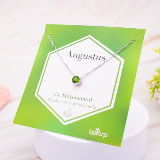 Collier argenté avec zircon vert sur carte verte 'Augustus'.