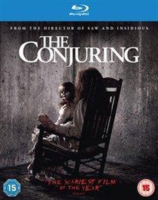 Een griezelige pop zit op de schoot van een vrouw in een schommelstoel, voor een betonnen muur. "The Conjuring" logo boven.