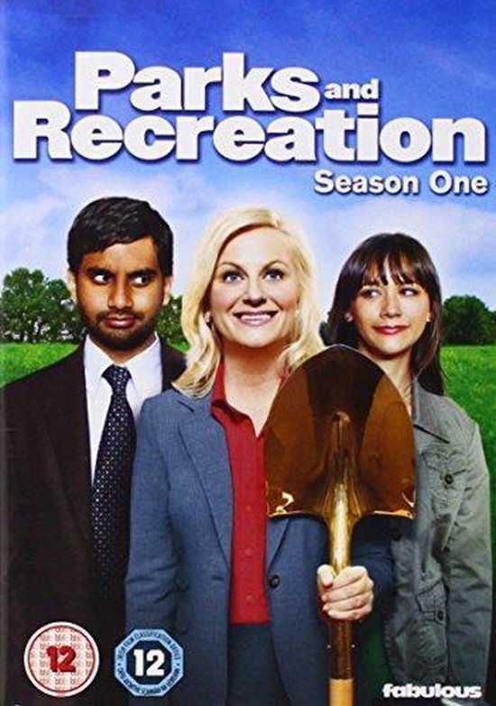 DVD-hoes met "Parks and Recreation Season One" logo. Drie hoofdrolspelers: een man met donker haar, een vrouw met blond haar die een schep vasthoudt, en een vrouw met donker haar.