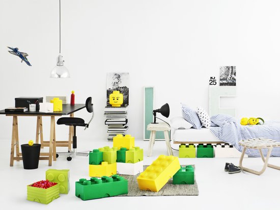 Kinderslaapkamer met LEGO opbergdozen, bureau, bed en speelgoed.