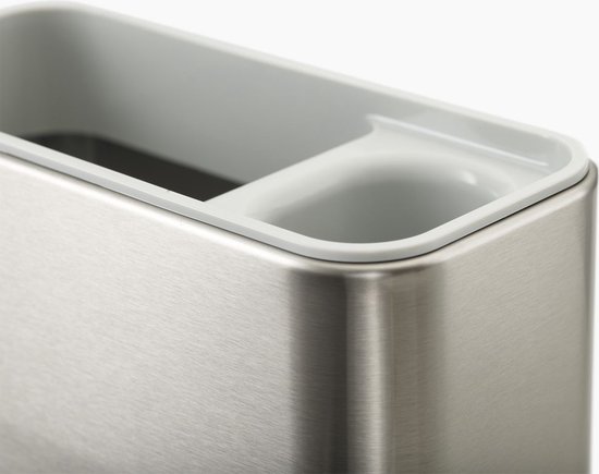 Binnenzijde van een zilverkleurige gootsteen organizer met een witte binnenrand.