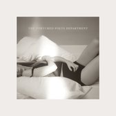 Een vrouw ligt in bed, in een zwart kledingstuk, op de schouders rustend op kussens, met de tekst 'THE TORTURED POETS DEPARTMENT' in de rechterbovenhoek.