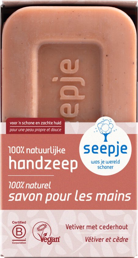 Een blok bruine handzeep, met "seepje" ingedrukt. De verpakking is in rood-oranje tinten met tekst in het Nederlands en Frans.