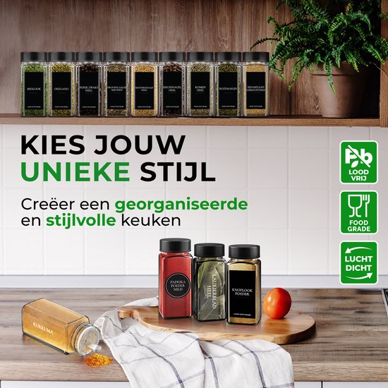 Bocaux à épices en verre avec couvercles noirs, placés sur une étagère en bois et un comptoir. Les bocaux contiennent du paprika rouge, des feuilles de laurier et de la poudre d'ail.