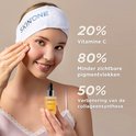 Vrouw met een hoofdband van SKINONE brengt serum aan. Tekst toont 20% Vitamine C, 80% minder pigmentvlekken, 50% verbeterde collageensynthese.