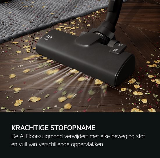 Zwarte AEG Allfloor stofzuigermond zuigt efficiënt stof en vuil op van een houten vloer en een donkergrijs vloerkleed.