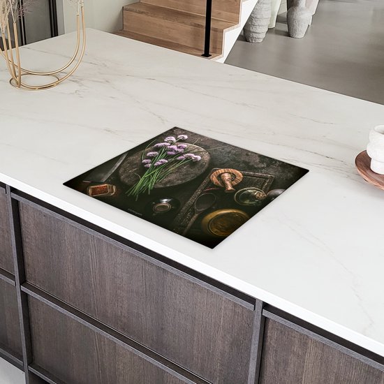 Inductiebeschermer met kruiden en specerijen op een keukenblad.