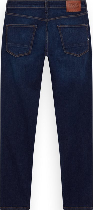Donkerblauwe jeans met gele sierstiksels en bruin label.