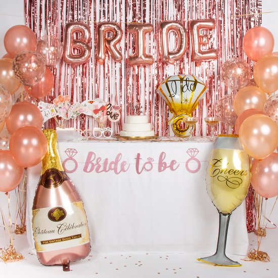 Décoration de table de fête : ballons "BRIDE", bouteille de champagne, verre, banderole "bride to be", voile de mariée, accessoires et une boîte Fissaly.