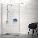 Une cabine de douche moderne avec murs carrelés blancs, garnitures de douche chromées et une chaise noire avec une serviette bleue.