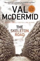 Boek 'The Skeleton Road' van Val McDermid, met een pad tussen stenen muren.