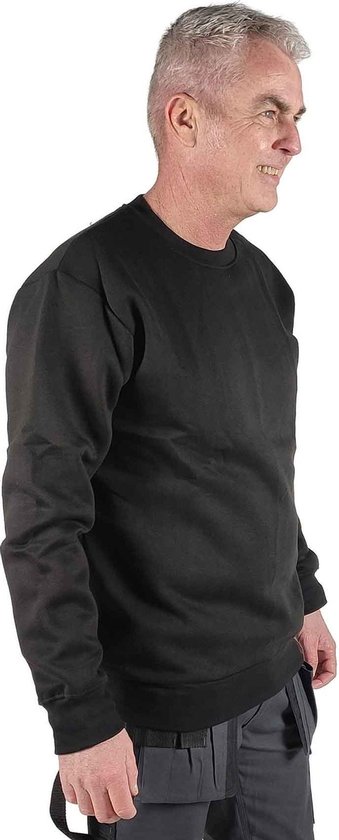 Un homme porte un sweatshirt noir à col rond STØRVIK, uni, manches longues.