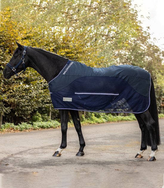 Zwarte paardendeken met navy blauwe mesh inzetstukken en witte bies. Merknaam 'WALDHAUSEN' op de deken.
