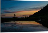 Dibond - Silhouet van Wandelenaar langs Meer in Berggebied tijdens de Avond - 105x70 cm Foto op Aluminium (Wanddecoratie van metaal)