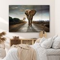 Un éléphant marche sur une route au coucher du soleil, affiché dans une chambre.