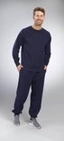 Man draagt een marineblauwe trui met ronde hals en een marineblauwe joggingbroek.