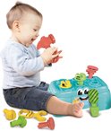 Baby met grijze trui en jeans speelt met turquoise werkbank speelgoed, hamer, schroeven en sleutels.