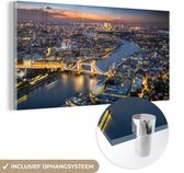 MuchoWow® Glasschilderij 120x60 cm - Schilderij acrylglas - Luchtfoto van Londen met de Tower Bridge tijdens schemering - Foto op glas - Schilderijen