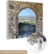MuchoWow® Glasschilderij 90x90 cm - Schilderij acrylglas - Uitzicht vanaf een stenen boog over een gemeente in Frankrijk - Foto op glas - Schilderijen