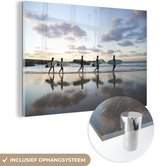 MuchoWow® Glasschilderij 90x60 cm - Schilderij acrylglas - Surfers langs het strand - Foto op glas - Schilderijen