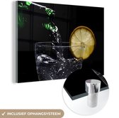MuchoWow® Glasschilderij 120x80 cm - Schilderij acrylglas - Een cocktail wordt ingeschonken op een zwarte achtergrond - Foto op glas - Schilderijen