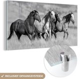 MuchoWow® Glasschilderij - Vier wilde mustang paarden rennen door het gras - zwart wit - 40x20 cm - Acrylglas Schilderijen - Foto op Glas