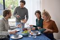 Quatre personnes assises à table utilisent des bols Mepal Cirqula pour un repas.