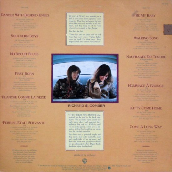 Twee vrouwen zitten in een auto, met op de achtergrond de tracklist van het album 'Dancer With Bruised Knees'.