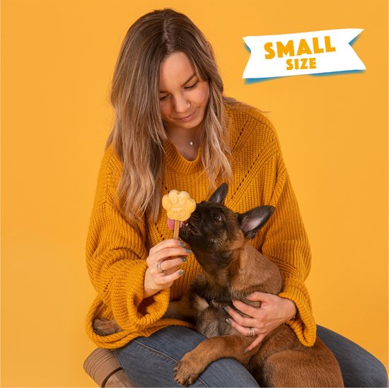 Vrouw met gele trui voedt puppy een lichtgroen pootvormig ijsje. "SMALL SIZE" is aangegeven.