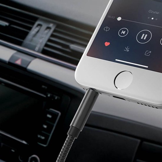 Câble audio noir à texture tressée, connecté à un smartphone dans un intérieur de voiture.