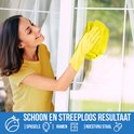 Une femme portant des gants jaunes nettoie une fenêtre avec un chiffon microfibre jaune.