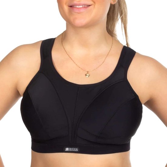 Vrouw met blond haar draagt een zwarte sportbeha en een gouden ketting met hartvormige hanger.