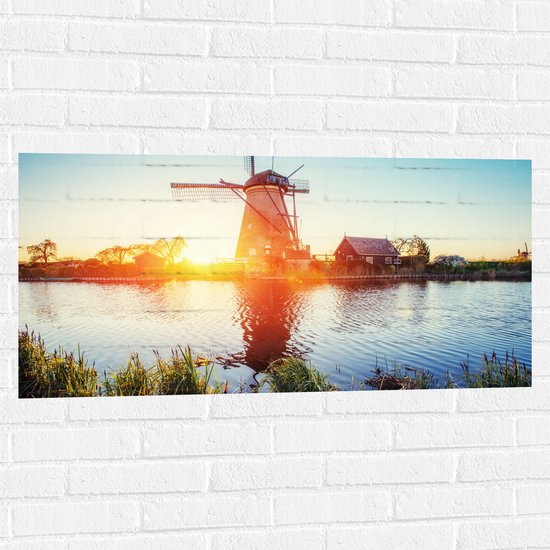WallClassics - Muursticker - Zonlicht langs Hollandse Molen aan het Water - 100x50 cm Foto op Muursticker