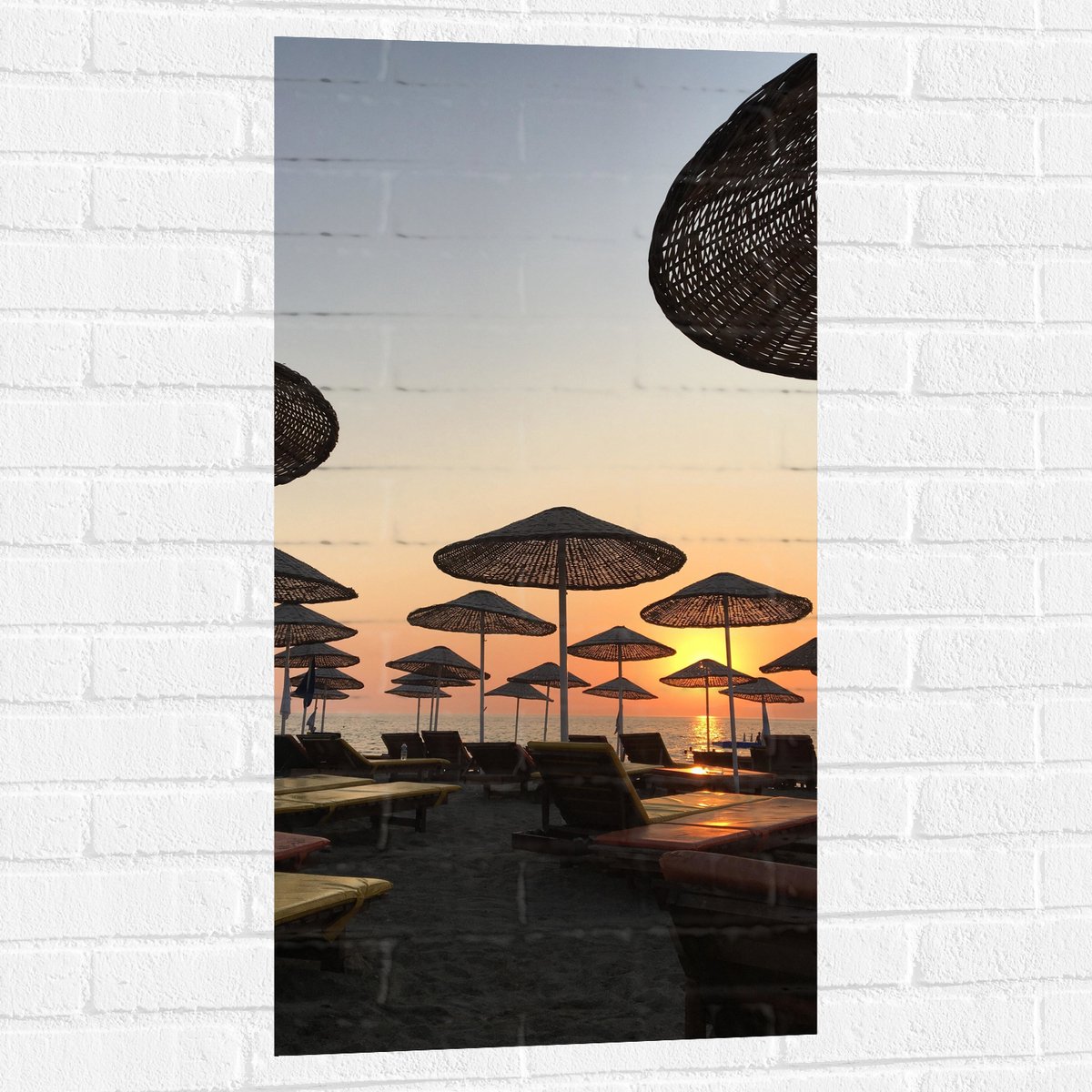Muursticker - Strand met Ligbedden en Rieten Parasols - 50x100 cm Foto op Muursticker