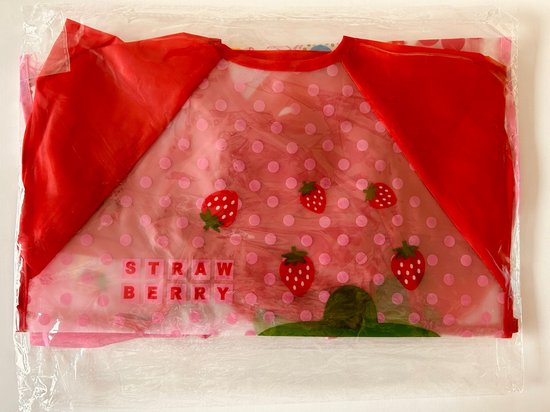 Rode slab met lange mouwen, verpakt in plastic. Aardbeienprint met roze stippen.