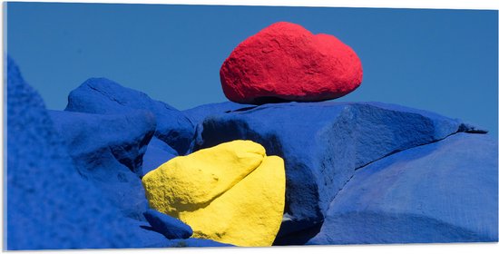 Acrylglas - Rode en Gele Kei op Blauwe Keien - 100x50 cm Foto op Acrylglas (Wanddecoratie op Acrylaat)