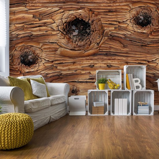 Mur décoratif avec un gros plan d'une planche de bois vieillie avec des nœuds. Un canapé blanc et une décoration jaune se trouvent devant.