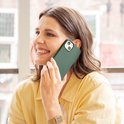 Vrouw met een groen telefoonhoesje aan de telefoon.