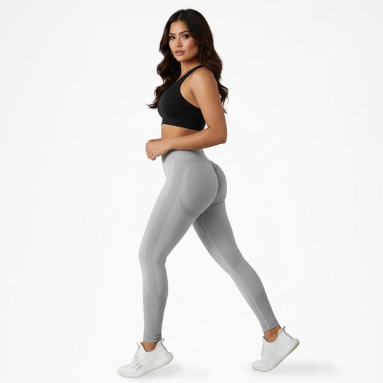 Model in grijze scrunch butt legging en zwarte sportbeha, naar de zijkant lopend.