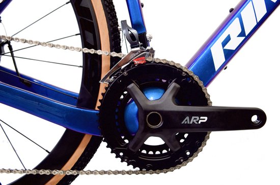 Gedetailleerde opname van de crankset en voorste derailleur van een blauwe Rinos gravelbike.