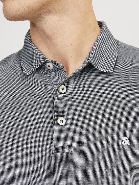 Close-up van de kraag en knoopsluiting van een grijs gemêleerd poloshirt met Jack & Jones logo.