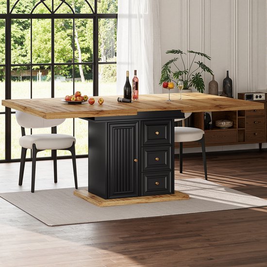 Houten tafel met 4 witte stoelen, 2 ervan aan de kopse kant. Donker onderstel met deur en laden, naast een kast.